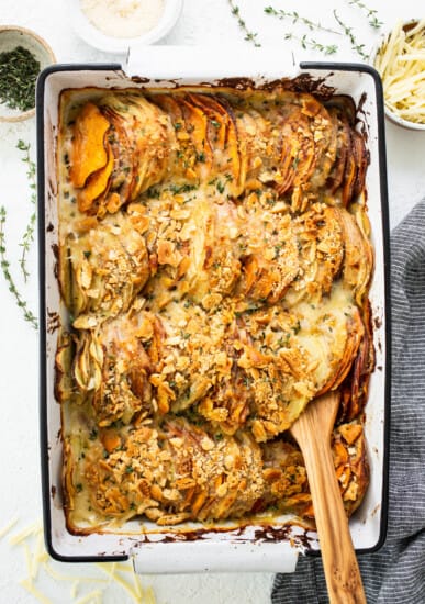 Sweet potato casserole in a baking dish with a wooden spoon.