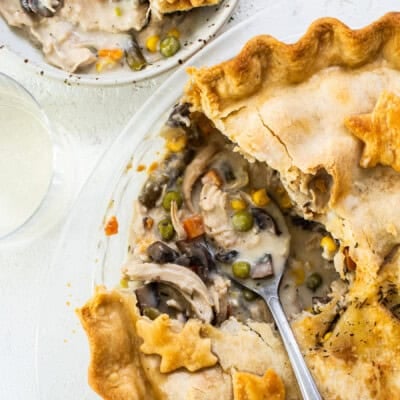 A chicken pot pie on a plate with a slice taken out.