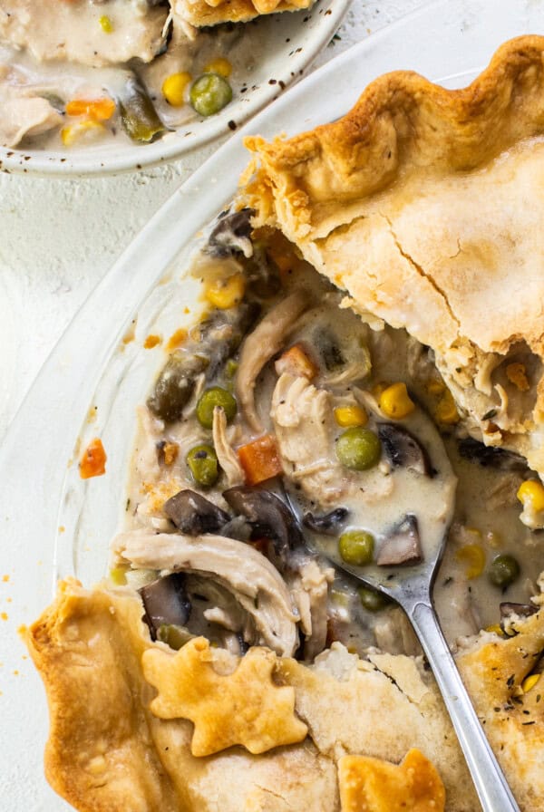 A chicken pot pie on a plate with a slice taken out.