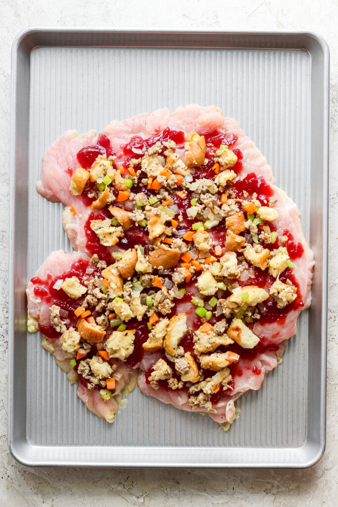 A baking sheet with turkey and cranberry topping on it.