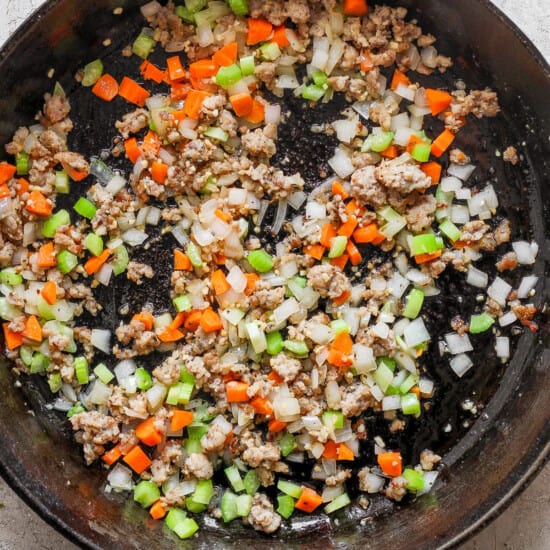 A cast iron skillet filled with meat and vegetables.