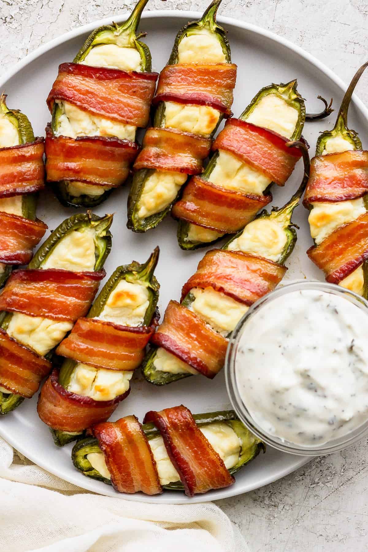 Bacon wrapped jalapenos on a plate.