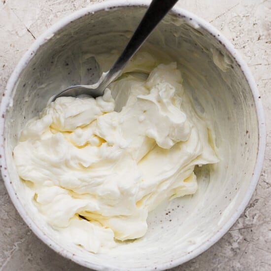 Whipped cream in a bowl with a spoon.
