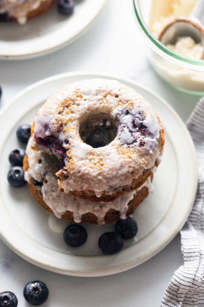 A stack of blueberry donuts on a plate.