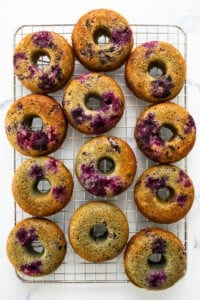 Blueberry donuts on a cooling rack.