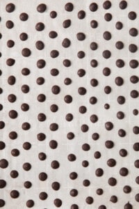 A black and white image of chocolate dots on a white background.