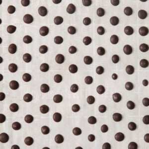 A black and white image of chocolate dots on a white background.