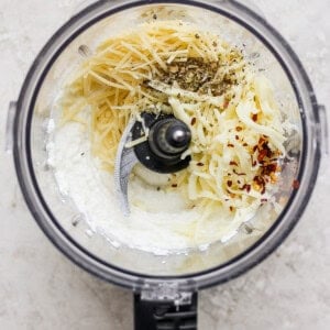 A food processor filled with ingredients for a pasta dish.
