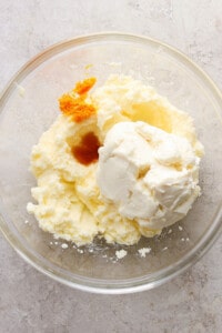 A bowl of whipped cream with a piece of orange in it.