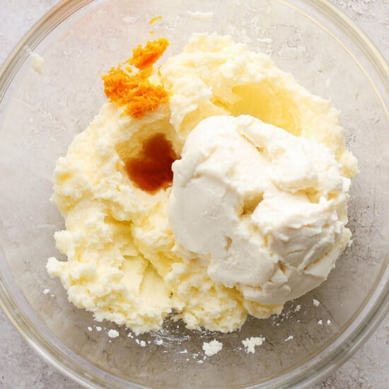 A bowl of whipped cream with a piece of orange in it.