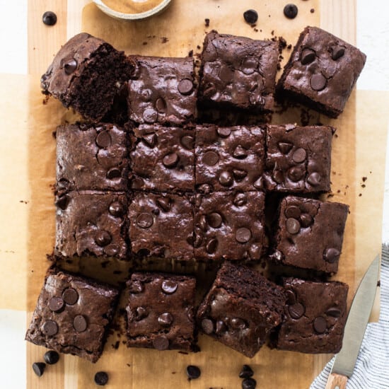 Chocolate brownies on a cutting board with peanut butter.