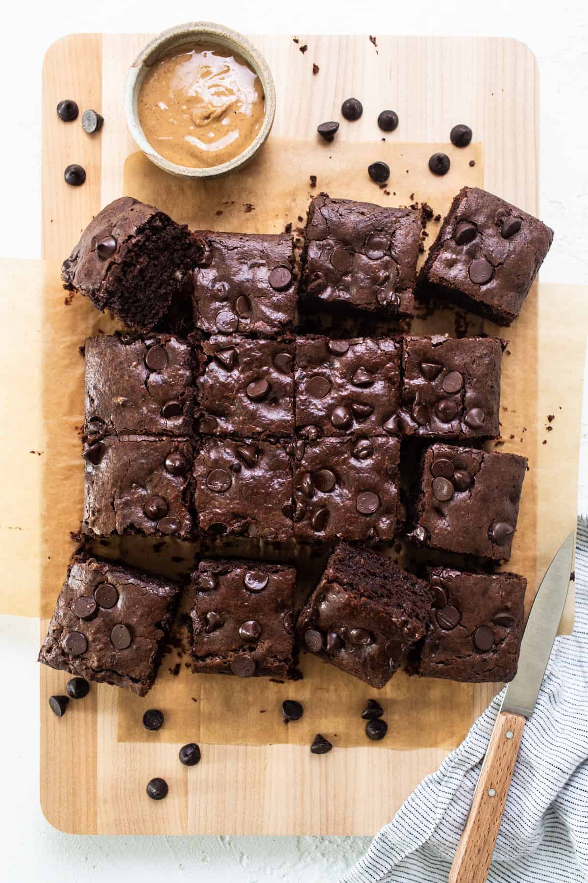 Chocolate brownies on a cutting board with peanut butter.