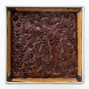 A brownie in a baking pan with chocolate chips.