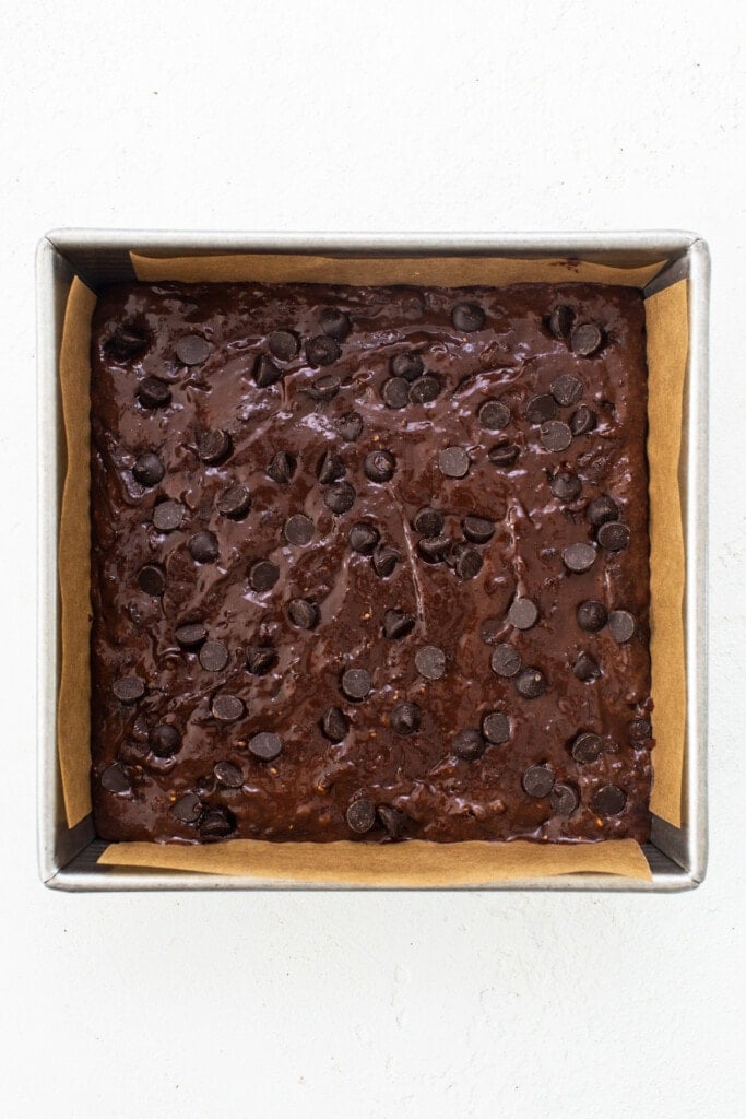 A brownie in a baking pan with chocolate chips.