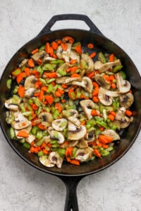 A skillet filled with mushrooms and carrots.