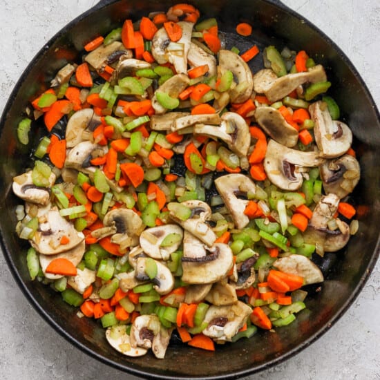 A skillet filled with mushrooms and carrots.