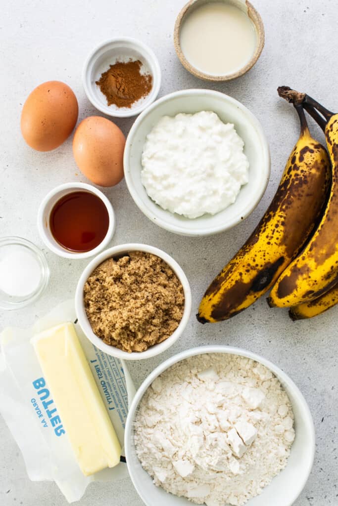 Banana bread ingredients such as bananas, flour, eggs and butter.