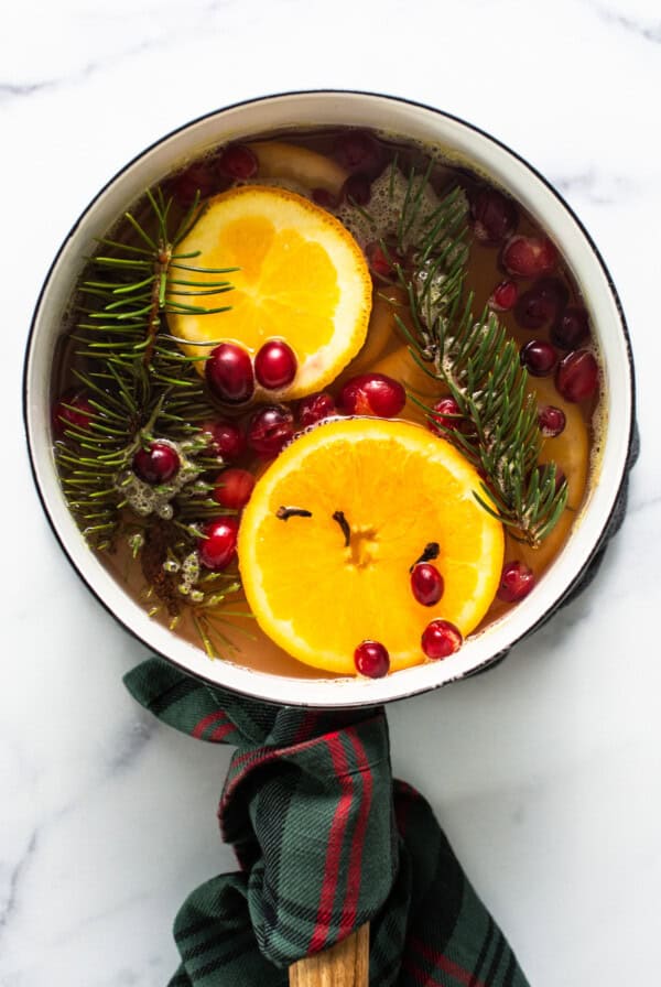 A pan with oranges, cranberries and sprigs of fir.