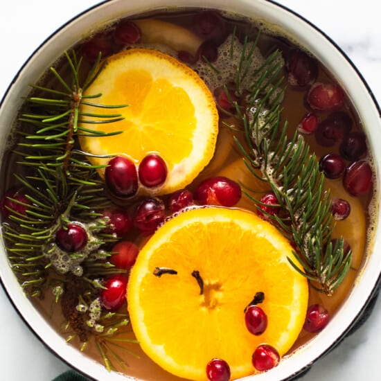 A pot with oranges, cranberries and sprigs of fir.