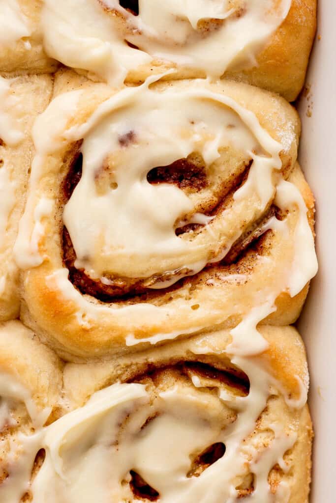 Cinnamon rolls in a baking dish with icing.