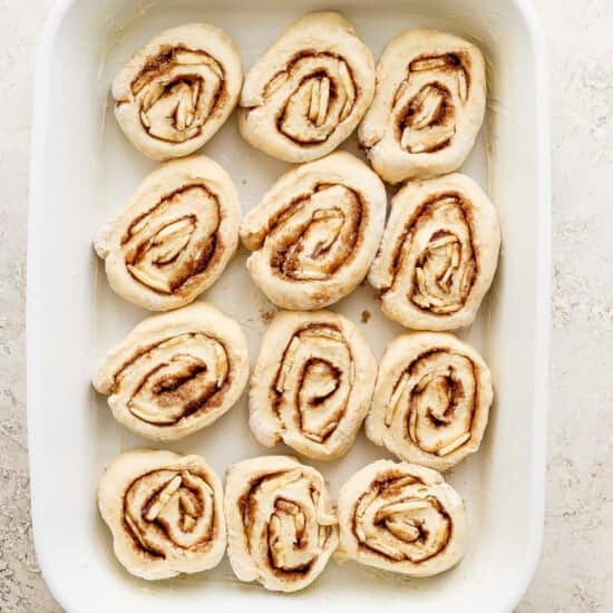 Cinnamon rolls in a white baking dish.