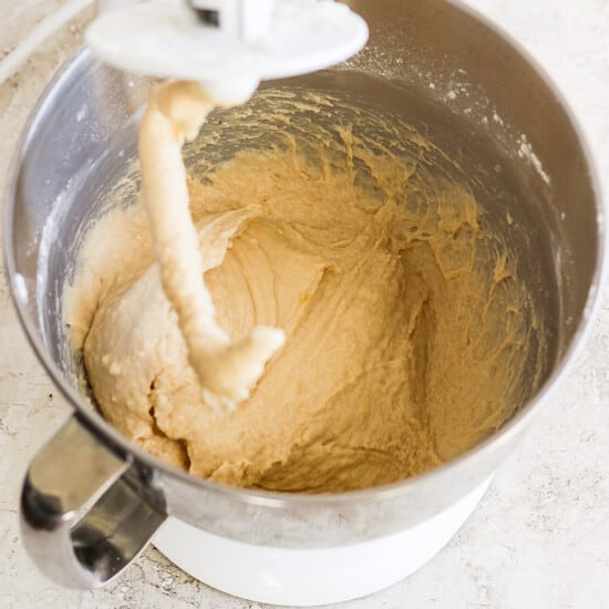 A bowl of dough being mixed in a mixer.