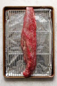 A piece of meat on a baking sheet.