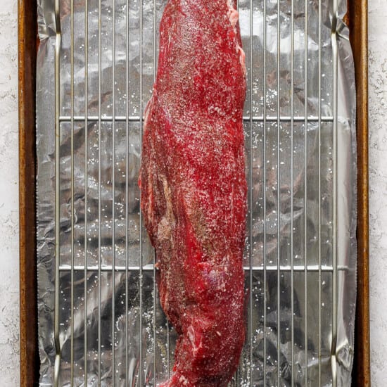 A piece of meat on a baking sheet.