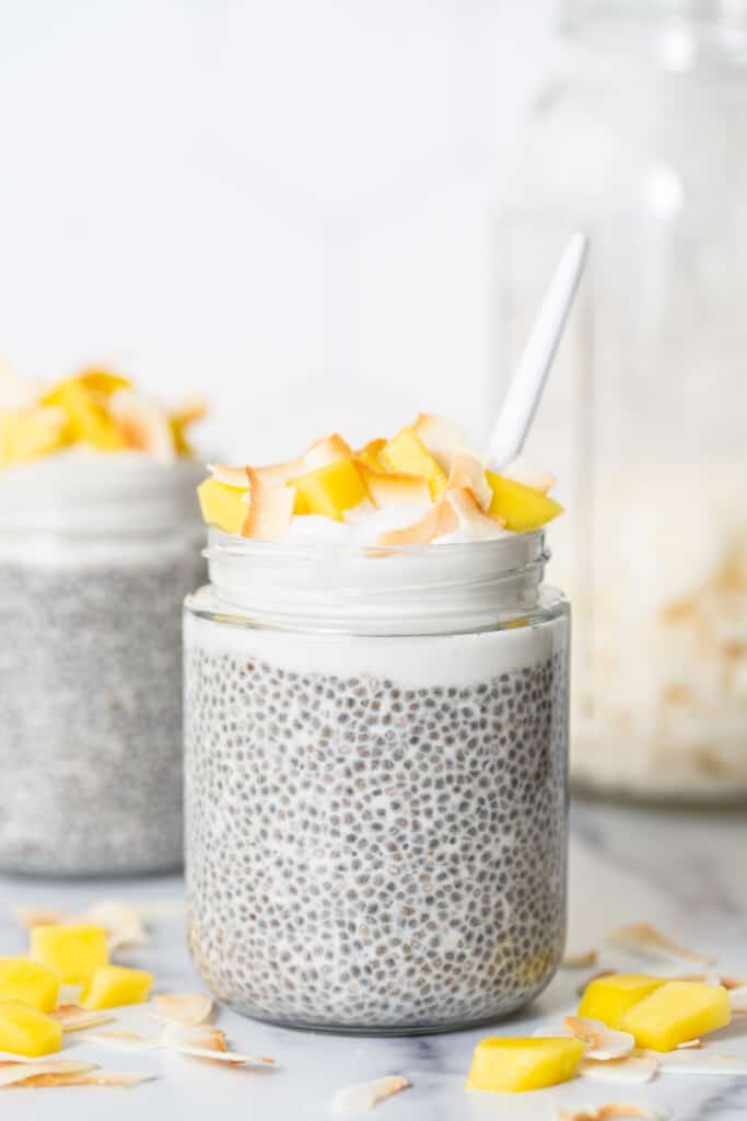 Two jars of chia pudding on a marble counter.