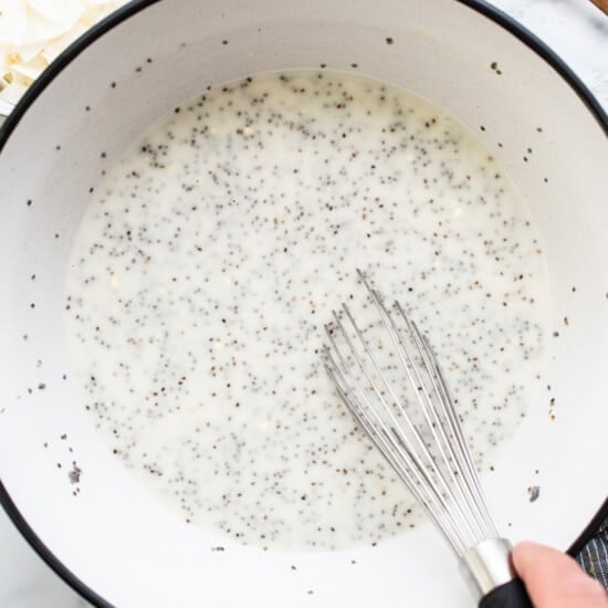 A person whisking chia seeds into a bowl.