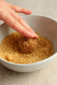 A person putting sugar into a bowl.