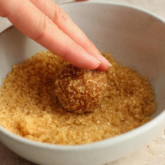 A person putting sugar into a bowl.