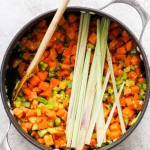 A pan with carrots and leeks in it.