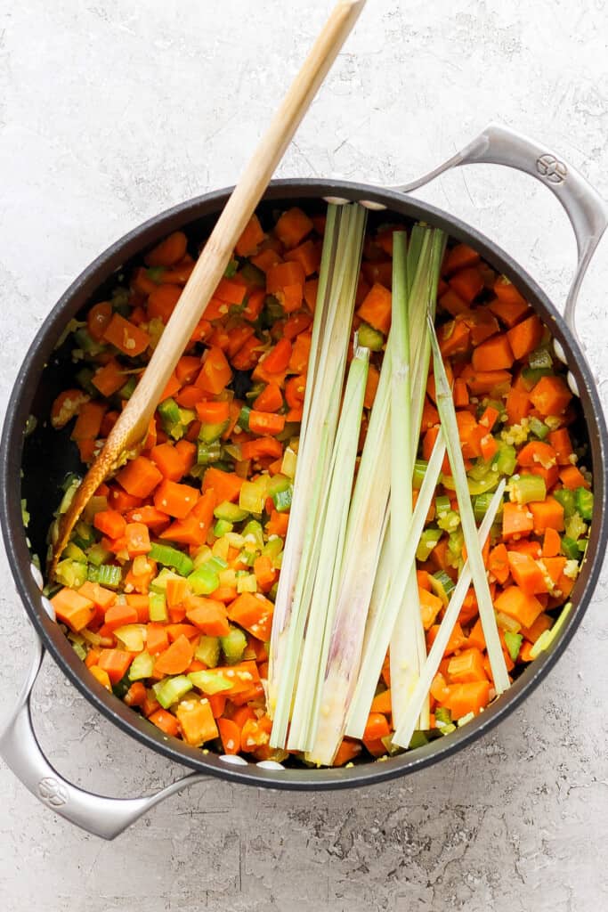 A pan with carrots and leeks in it.