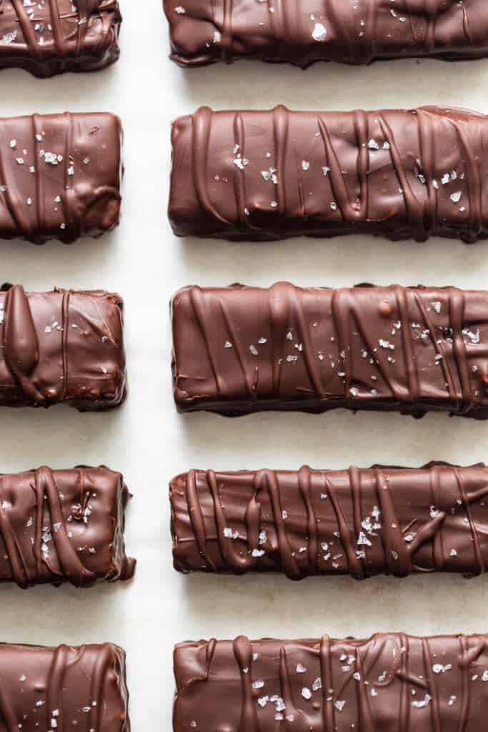A row of chocolate covered bars on a white surface.