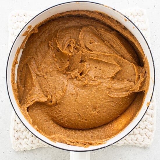 Pumpkin butter in a pan with a wooden spoon.