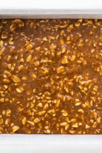 A baking dish filled with caramel and nuts.