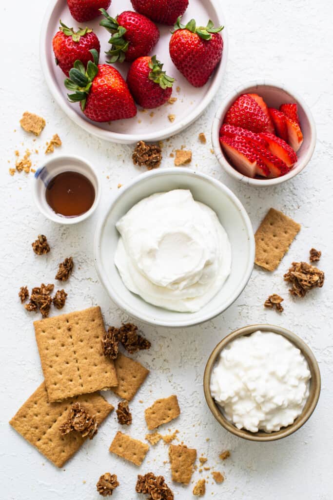Strawberries, graham ،ers and whipped cream on a white background.