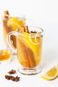 A cup of lemon tea with cinnamon and star anise.