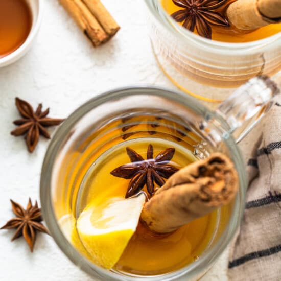 A cup of mulled wine with cinnamon sticks and star anise.