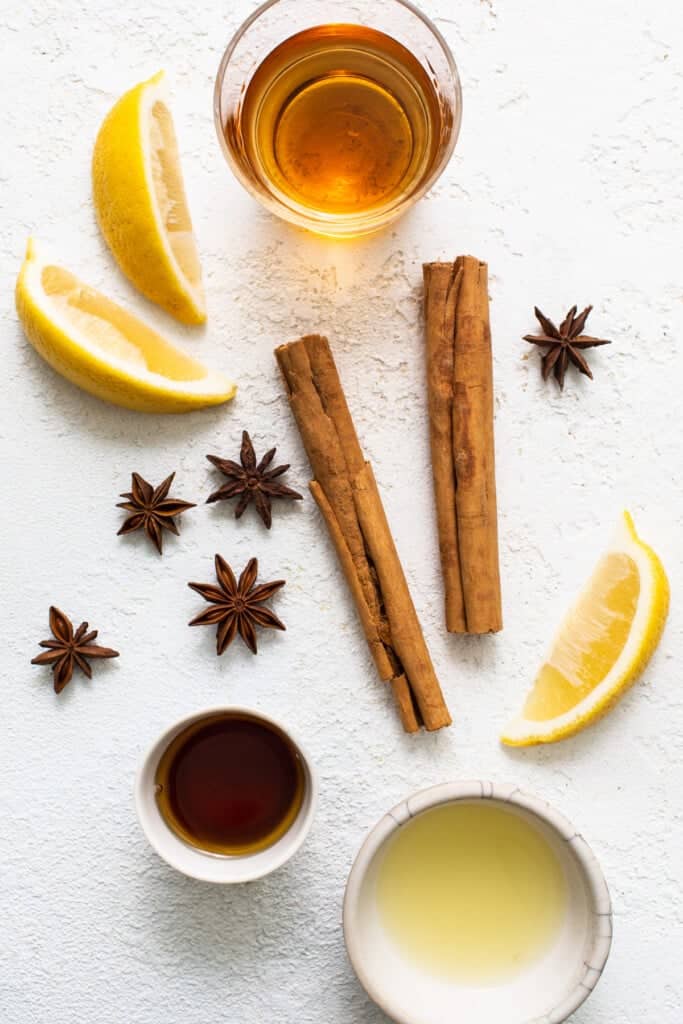 Cinnamon, lemon, star anise and honey on a white background.