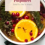 A pot with cranberries and oranges in it with the text stovetop potpourri smells like christmas.