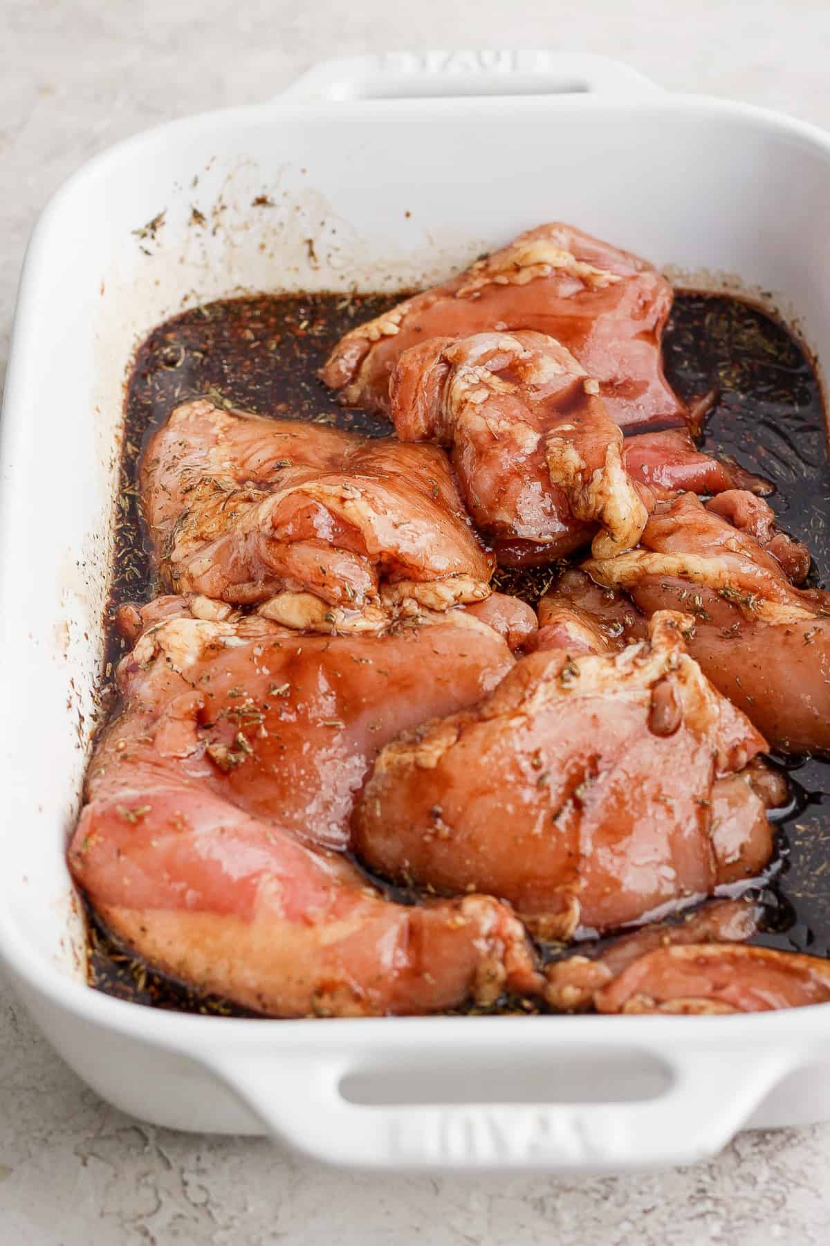 Chicken breasts in a baking dish with sauce.