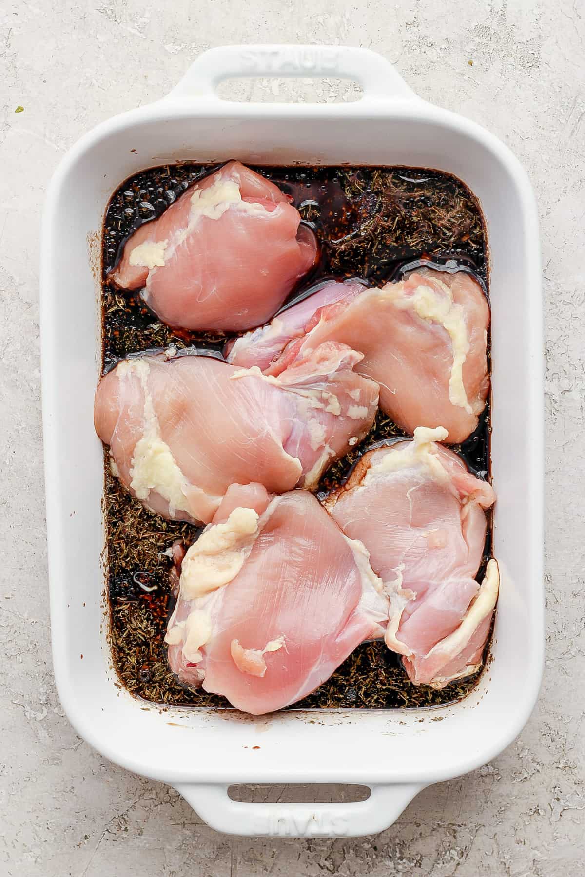 Chicken breasts in a white baking dish.