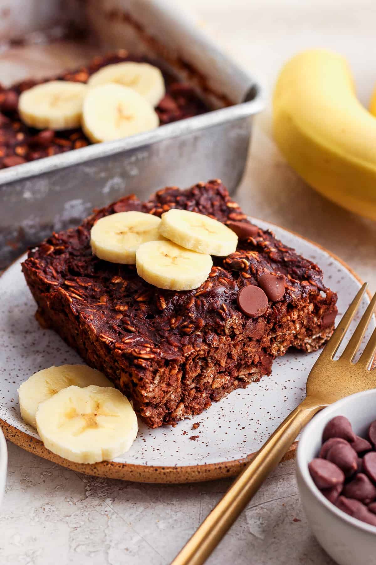 Chocolate banana granola bars on a plate with banana slices.