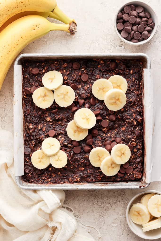 A baking pan with banana slices and chocolate chips.
