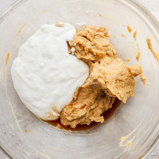 The ingredients for peanut butter cookie dough in a glass bowl.
