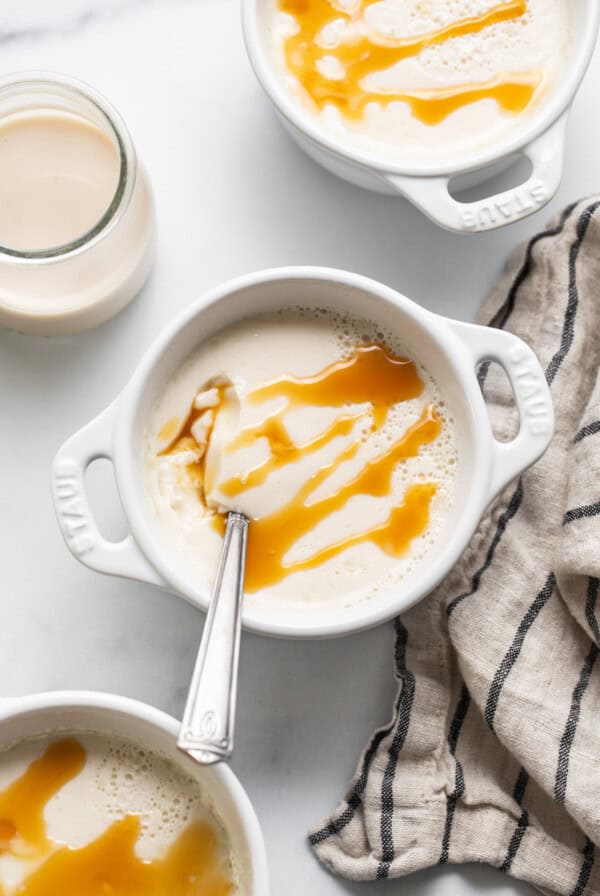 A bowl of ice cream with caramel sauce and a spoon.