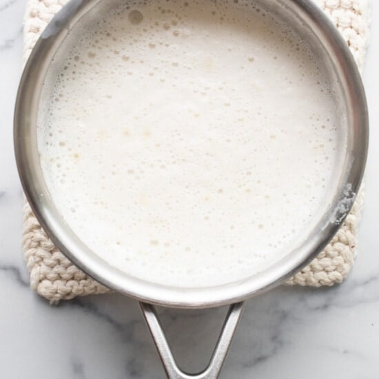 A pan with milk in it on a marble countertop.