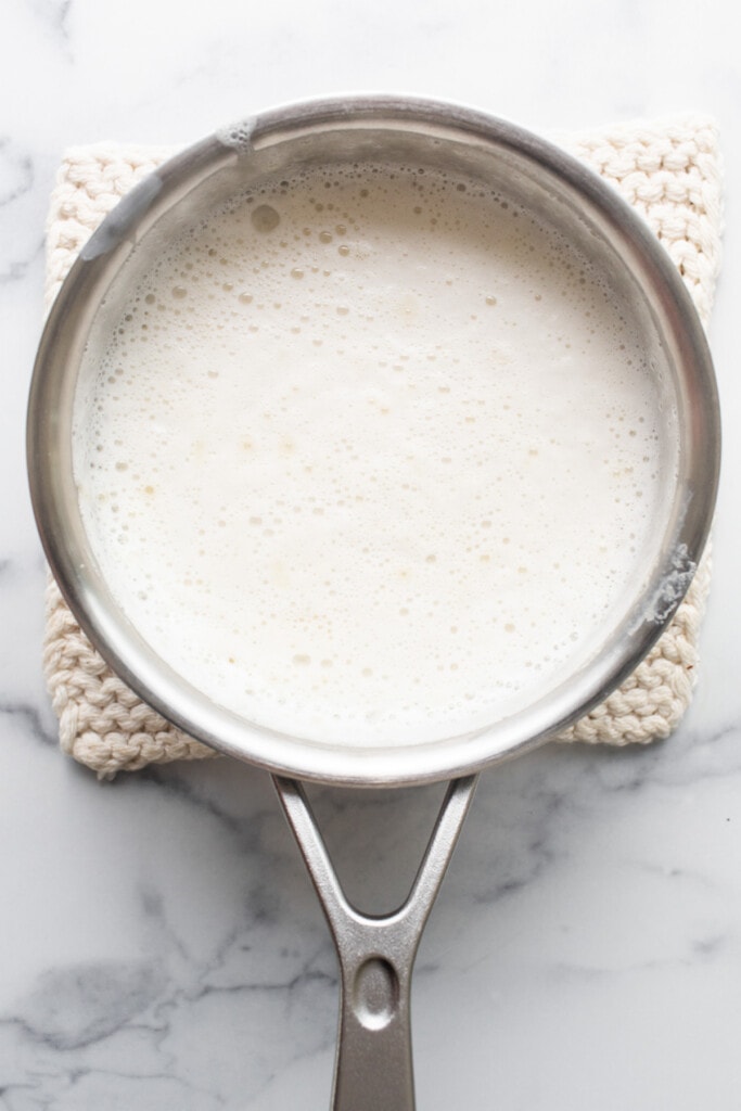 A pan with milk in it on a marble countertop.